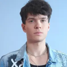 Kris Cugowski w jeansowej kurtce z ćwiekami i naszyjnikiem.