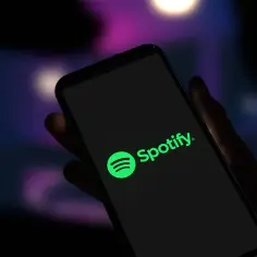 Dłoń trzyma smartfon z logo Spotify. Czas na podsumowanie roku, kiedy Spotify Wrapped!