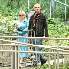 Margaret z mężem spacerują z psami po zielonym parku.