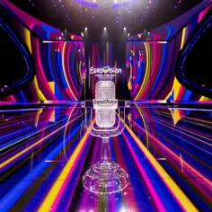 Kryształowy mikrofon na scenie Eurowizji, gotowy na występy Wielkiej Piątki. Kolorowe światła tworzą magiczną atmosferę.