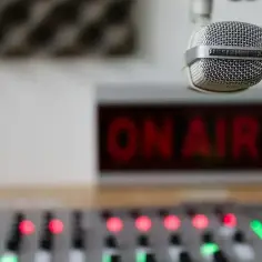 Mikrofon gotowy do nadawania. Na ekranie świeci się "ON AIR", a mikser czeka na sygnał. Słuchasz Radio Eska częstotliwość?