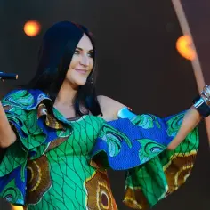Kayah w barwnej sukni z afrykańskim wzorem, śpiewa na scenie. Jej pochodzenie inspiruje twórczość.
