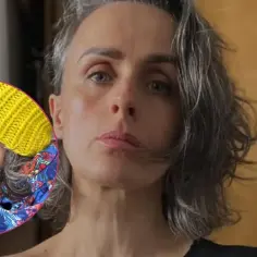Natalia Niemen z dziećmi, w żółtej czapce i kolorowym szaliku, przytulająca jedno z dzieci.