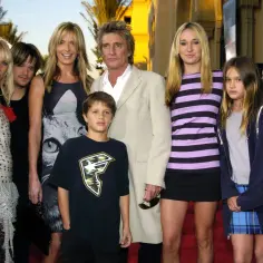 Rod Stewart z rodziną: żona i dzieci pozują na czerwonym dywanie.