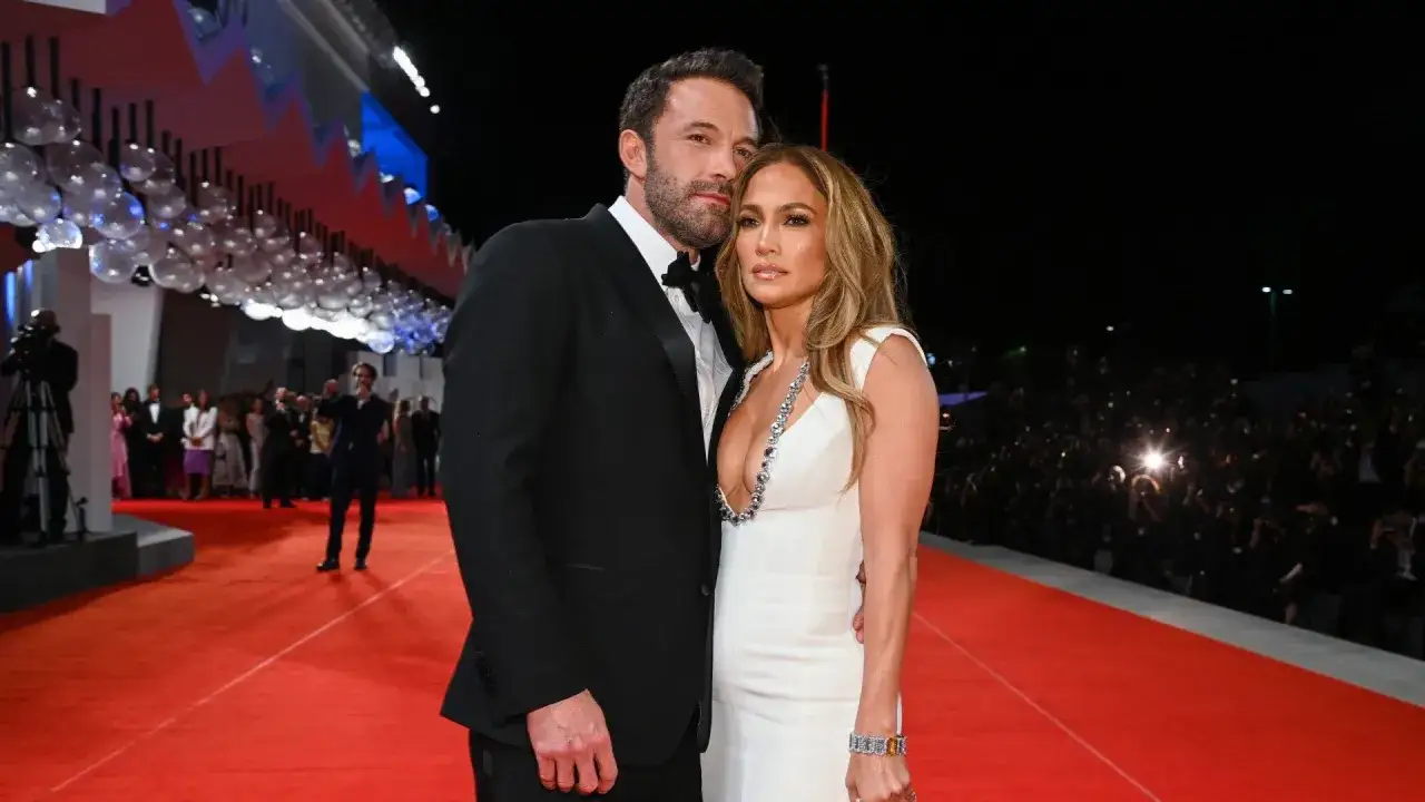 Jennifer Lopez i jej mąż Ben Affleck na czerwonym dywanie, otoczeni tłumem fotoreporterów.