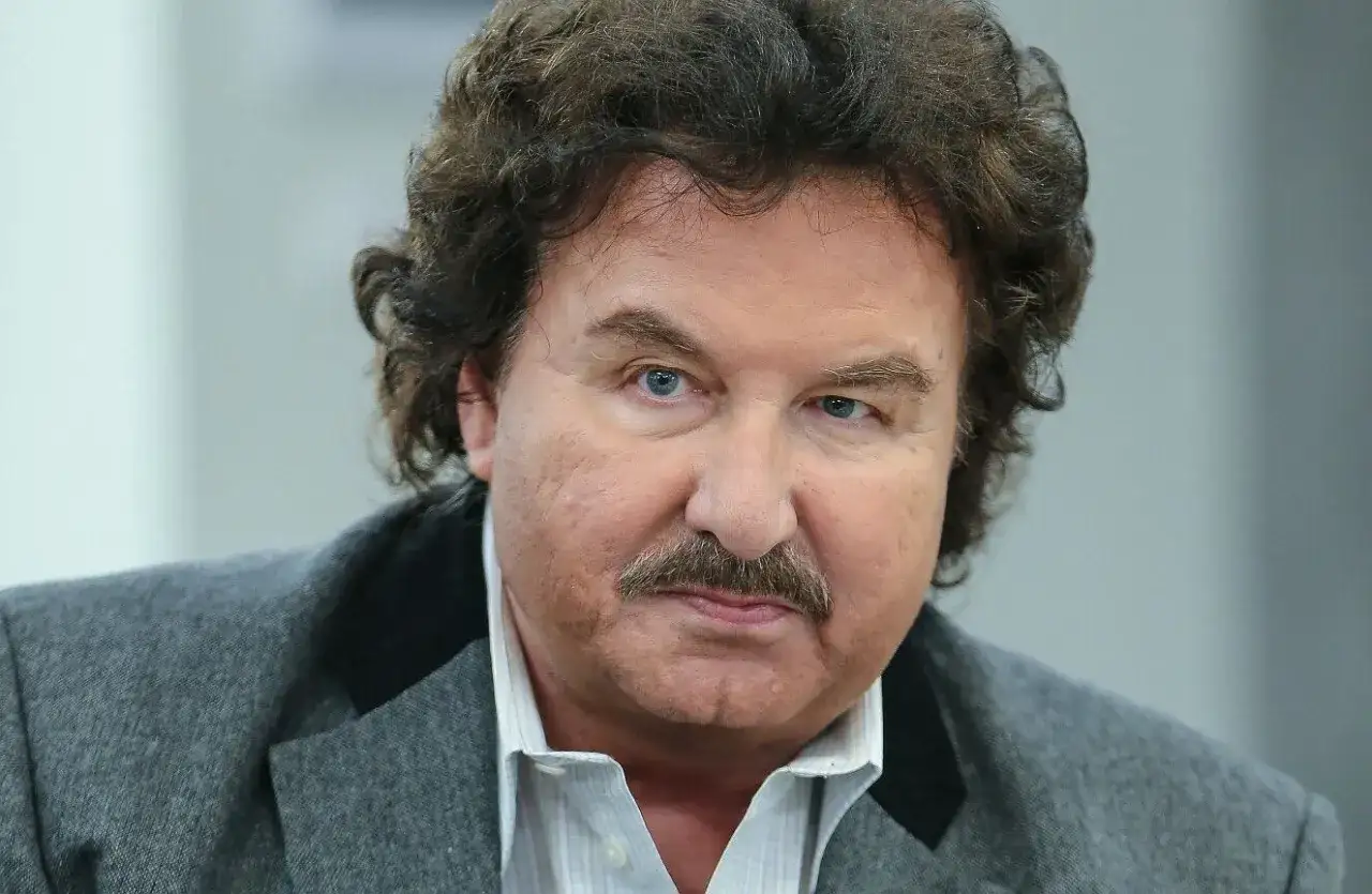 Zbliżenie na twarz Krzysztofa Krawczyka. Wiek artysty nie jest widoczny, ale jego charakterystyczny wąs i spojrzenie są rozpoznawalne.