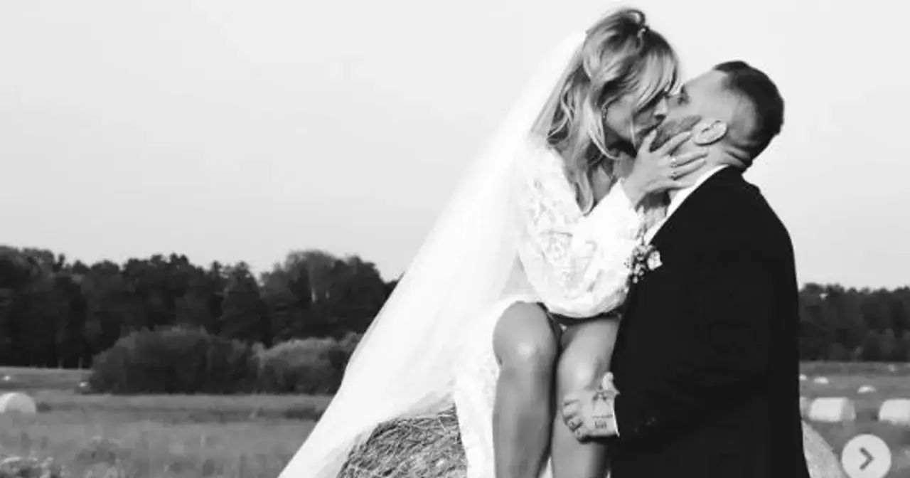Patrycja Markowska z mężem w dniu ślubu, siedzą na balu siana, całując się.